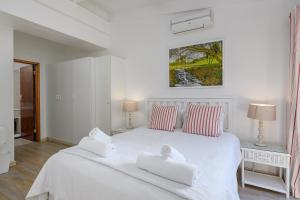 a white bedroom with a white bed with two towels at San Lameer Villa 2610 - 4 Bedroom Classic - 8 pax - San Lameer Rental Agency in Southbroom