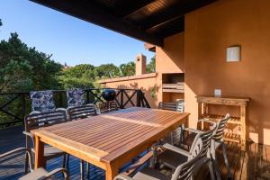 d'une table et de chaises en bois sur un balcon avec cheminée. dans l'établissement San Lameer Villa 2610 - 4 Bedroom Classic - 8 pax - San Lameer Rental Agency, à Southbroom