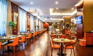 Crowne Plaza Beijing Zhongguancun, an IHG Hotel في بكين: غرفة طعام مع طاولات وكراسي في مطعم