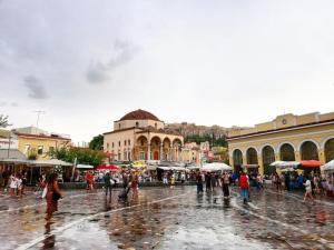a group of people walking around a market in the rain at AS Monastiraki Apartment 1B in Athens