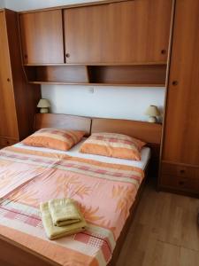 a bedroom with two beds and wooden cabinets at Apartments by the sea Supetarska Draga - Donja, Rab - 17201 in Rab
