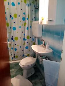 a bathroom with a toilet and a sink at Apartments by the sea Supetarska Draga - Donja, Rab - 17201 in Rab