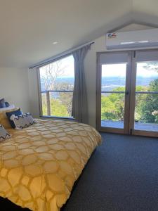1 dormitorio con 1 cama grande y ventanas grandes en Vista Views, en Mount Dandenong