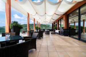 キェルツェにあるOdyssey ClubHotel Wellness&SPAのテーブルと椅子、窓のあるレストラン