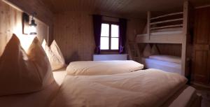 2 bedden in een kamer met een stapelbed bij Vorderkaseralm in Sankt Johann im Pongau