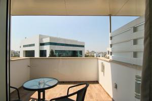 balkon ze stołem i krzesłami oraz budynek w obiekcie Phaedrus Living: Luxury Suite Nicosia 506 w Nikozji