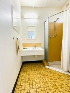 a bathroom with a tub and a sink and a shower at Mid Valley Motel in Morwell