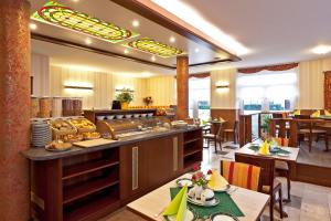 a restaurant with a counter and some tables and chairs at Hotel Für Dich in Waren