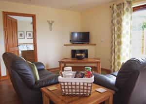a living room with two leather chairs and a table at Heart Of Wales Lodges in Penybont