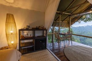 a bedroom with a bed and a table and chairs at Sanda Plantation Hideaway in Sanda