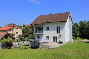 ein großes weißes Haus mit einem Hof und einem Haus in der Unterkunft Apartments for families with children Slunj, Plitvice - 17416 in Slunj