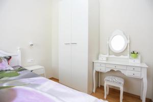 Schlafzimmer mit einem weißen Schminktisch und einem Spiegel in der Unterkunft Apartments for families with children Slunj, Plitvice - 17416 in Slunj