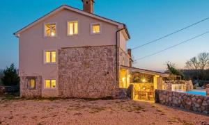 duży kamienny dom z basenem przed nim w obiekcie Luxury villa with a swimming pool Garica, Krk - 17469 w mieście Risika +10 zdjęć
