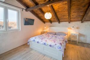sypialnia z łóżkiem w pokoju z drewnianym sufitem w obiekcie Luxury villa with a swimming pool Garica, Krk - 17469 w mieście Risika