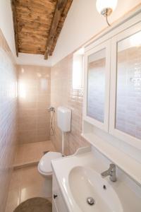 a white bathroom with a toilet and a sink at Luxury villa with a swimming pool Garica, Krk - 17469 in Risika