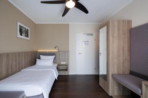 a bedroom with two beds and a ceiling fan at Hotel Jellentrup - Adults Only in Münster