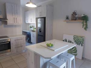 a kitchen with a white counter top and a stove top oven at Flower Route House in Langebaan