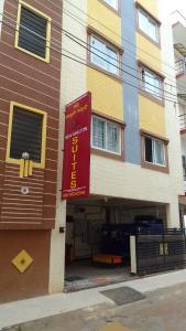 a building with a red sign in front of it at HOTEL NEW SHELTON SUITES in Bangalore