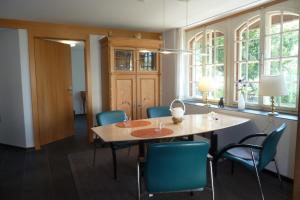 a dining room with a table and blue chairs at Ferienwohnung-Brienz in Brienz