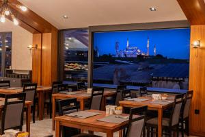 a restaurant with wooden tables and a large window at Demiray Hotel Old City in Istanbul