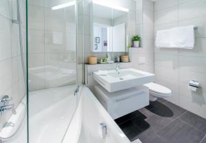 a white bathroom with a sink and a toilet at Panoramapark Soleil Chalet B in Wengen