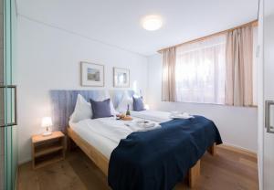 a bedroom with a large bed with a blue blanket at Panoramapark Soleil Chalet B in Wengen