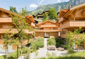 a resort with mountains in the background with a courtyard at Panoramapark Soleil Chalet B in Wengen