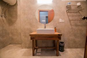 ein Badezimmer mit einem Waschbecken und einem Spiegel auf dem Tisch in der Unterkunft Tibet Hotel in Skardu