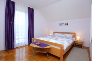 Schlafzimmer mit einem Bett, einem Tisch und einem Fenster in der Unterkunft Apartments with a parking space Donje Taboriste, Plitvice - 17527 in Slunj