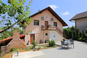 a house with a table in front of it at Apartments and rooms with a swimming pool Grabovac, Plitvice - 17531 in Rakovica