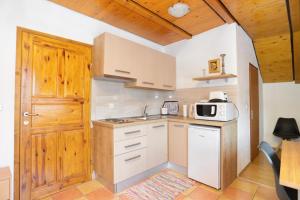 a kitchen with white cabinets and a wooden door at Apartments and rooms with a swimming pool Grabovac, Plitvice - 17531 in Rakovica