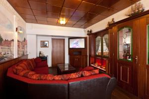 a living room with a red couch and a television at Hotel Für Dich in Waren