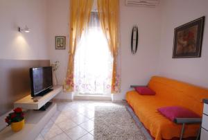 a living room with an orange couch and a television at Apartments Marmont in Split