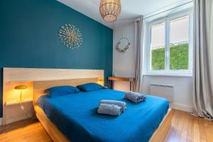 安锡Apt 2-4 pers, charme de l'ancien, calme, vélos, Annecy centre的蓝色卧室配有一张带蓝色床单的大床