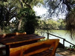 un banco de madera sentado junto a un cuerpo de agua en Mkolo Hunting and Wildlife, 