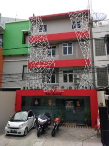 a car and motorcycles parked in front of a building at City Biz Residence in Jakarta