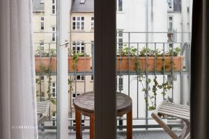 a table and chairs on a balcony with plants at Axel Guldsmeden in Copenhagen