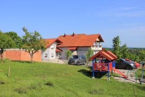 a playground in a yard in front of a house at Apartments for families with children Lipovac, Plitvice - 17556 in Rakovica