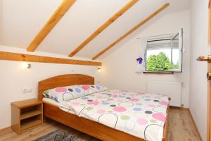 a bedroom with a bed and a window at Apartments for families with children Lipovac, Plitvice - 17556 in Rakovica