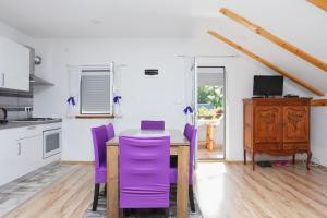 a kitchen with a table and purple chairs at Apartments for families with children Lipovac, Plitvice - 17556 in Rakovica