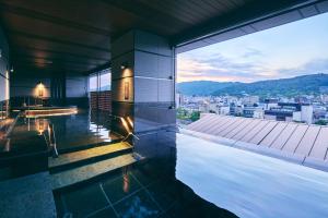 a building with a pool and a view of a city at Sora Niwa Terrace Kyoto Bettei in Kyoto