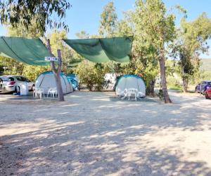 a group of tents and chairs in a parking lot at Camping la Naranja in Gandía