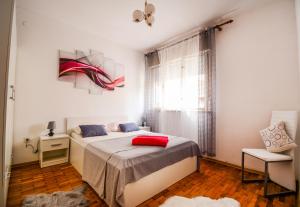 sypialnia z łóżkiem z czerwoną poduszką w obiekcie Family friendly apartments with a swimming pool Zadar - 17553 w mieście Zadar
