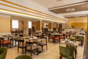 um restaurante com mesas e cadeiras e um bar em Starlit Suites Tirupati em Tirupati