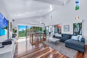 ein Wohnzimmer mit einem Sofa und einem Tisch in der Unterkunft MANDALAY ESCAPE, SECLUSION & SERENITY WITH A POOL in Airlie Beach