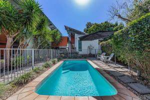 a swimming pool in the backyard of a house at MANDALAY ESCAPE, SECLUSION & SERENITY WITH A POOL in Airlie Beach