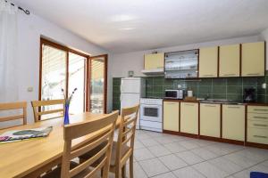 a kitchen with a wooden table and a dining room at Apartment Drage 17392a in Pakoštane