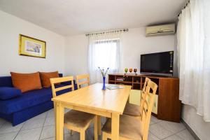 a living room with a table and a blue couch at Apartment Drage 17392a in Pakoštane