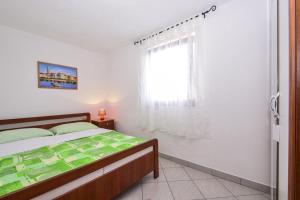 a bedroom with a bed and a window at Apartments with a parking space Drage, Biograd - 17392 in Pakoštane