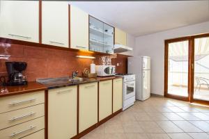 a kitchen with a sink and a refrigerator at Apartments with a parking space Drage, Biograd - 17392 in Pakoštane